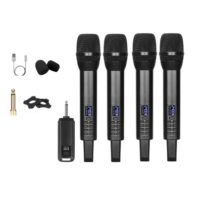 Four black handheld wireless microphones with digital LCD screens are shown on a white background, alongside accessories including a USB cable, two black foam windshields, a gold-tone jack adapter, a black clip, a small instruction booklet, and a separate black receiver unit.